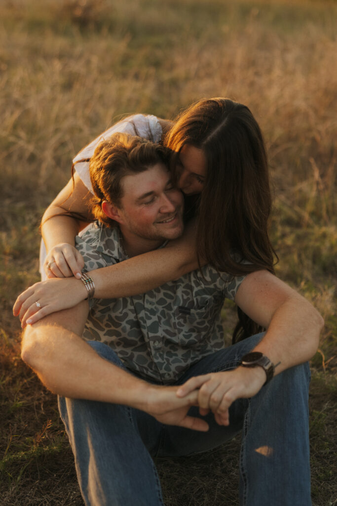 Couple sitting in a field during sunset in Dallas, Texas