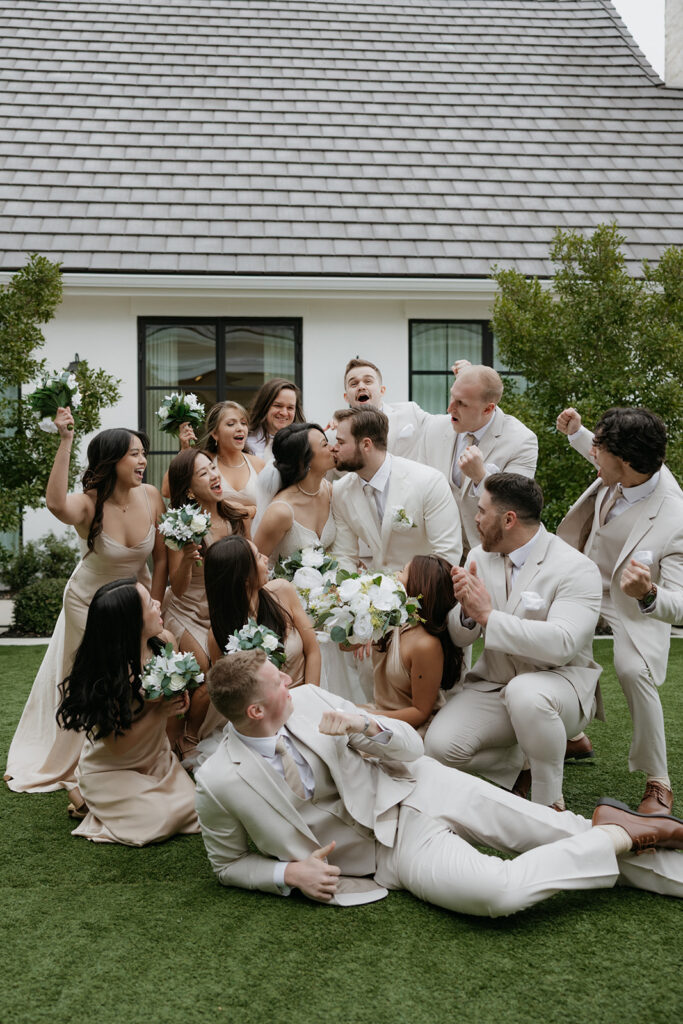 bridal party cheering as bride and groom kiss