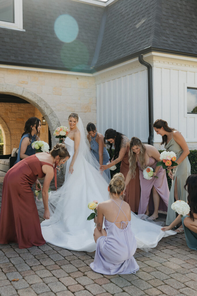 bridesmaids helping bride with her dress