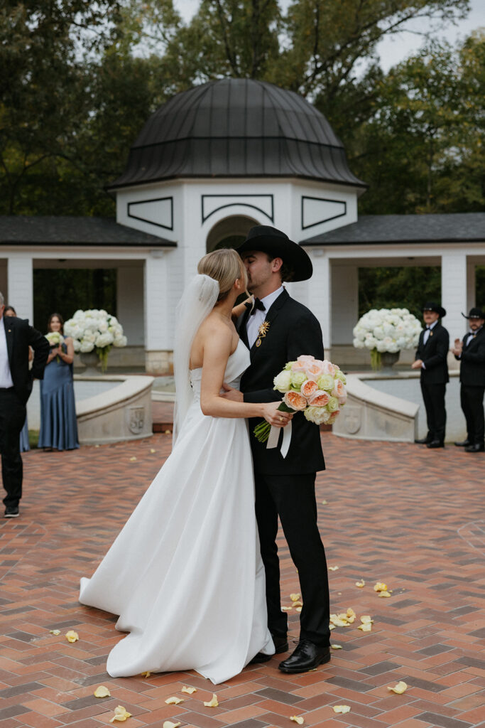 bride and groom kissing at the end of the aisle during wedding ceremony
