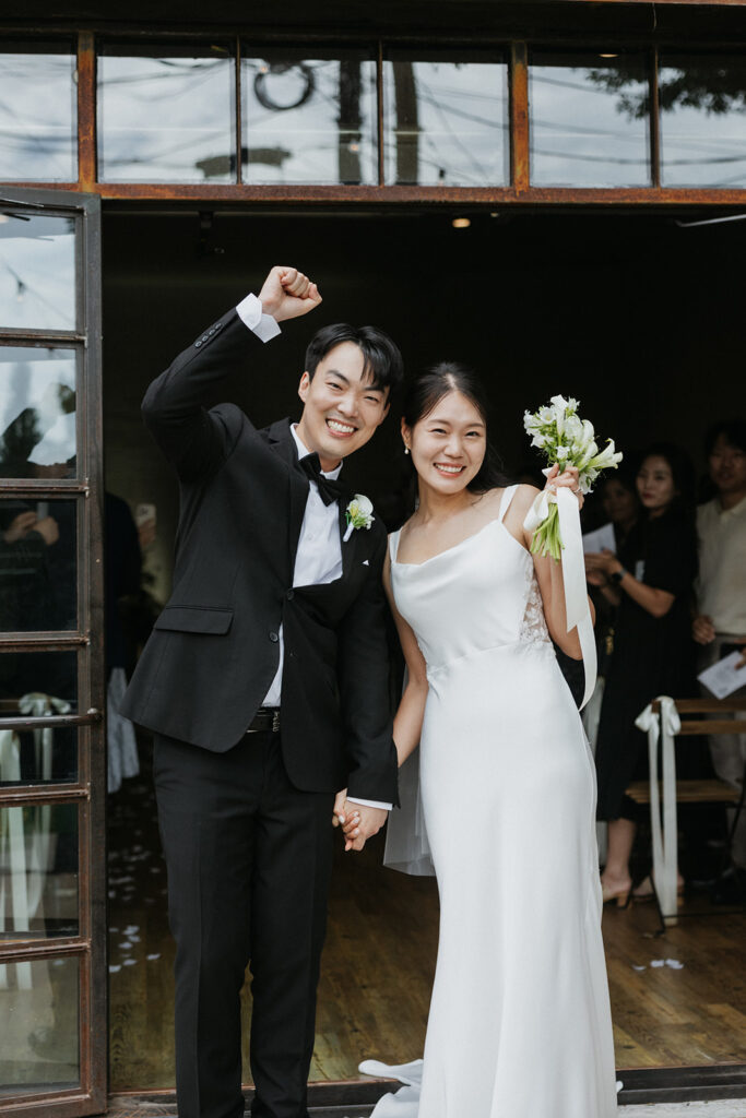 The couple cheers as they exit the ceremony at One Eleven East Hutto, Texas.