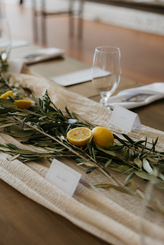 Wedding reception tablescape with greenery and fresh lemons on each table.