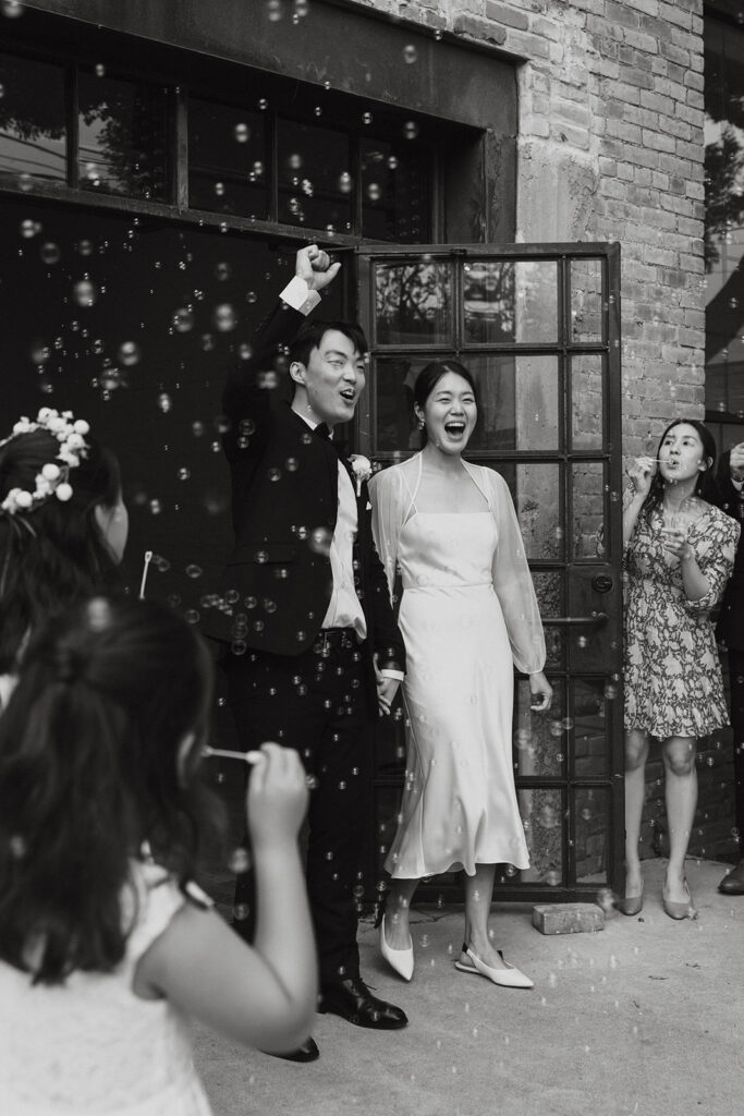Bride and groom walking out of the door at One Eleven East Hutto Texas for their grand exit.