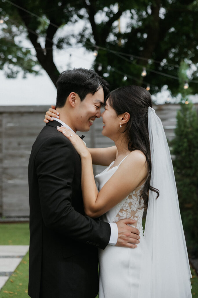 Bride and groom about to kiss as they hold one another outside of One Eleven East Hutto, Texas.