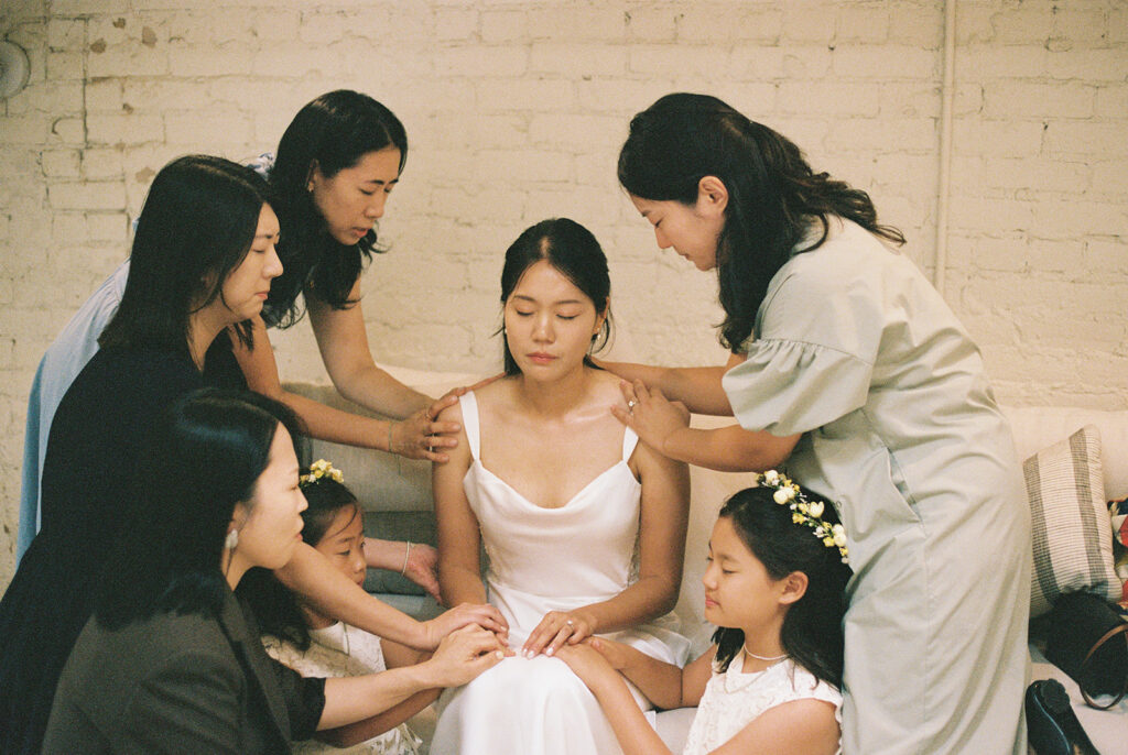 Bridal party saying a heart-felt prayer over the bride at the Christ centered wedding.