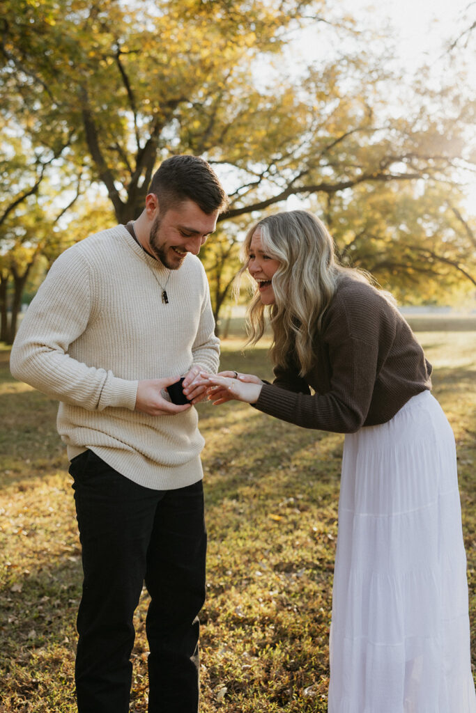 A couple smiling and crying during a surprise proposal. 