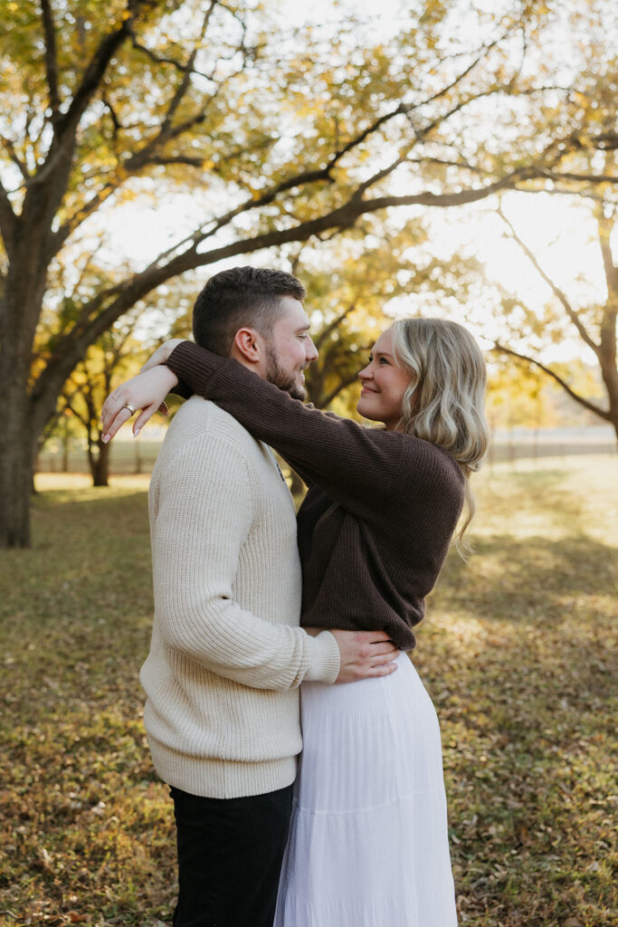 A girl with her arms around the neck of her fiancé at Elmer W. Oliver Nature Park.