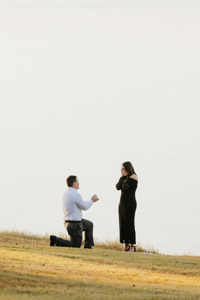 Man proposing to his girlfriend with surprise proposal photos at Waco Lake.