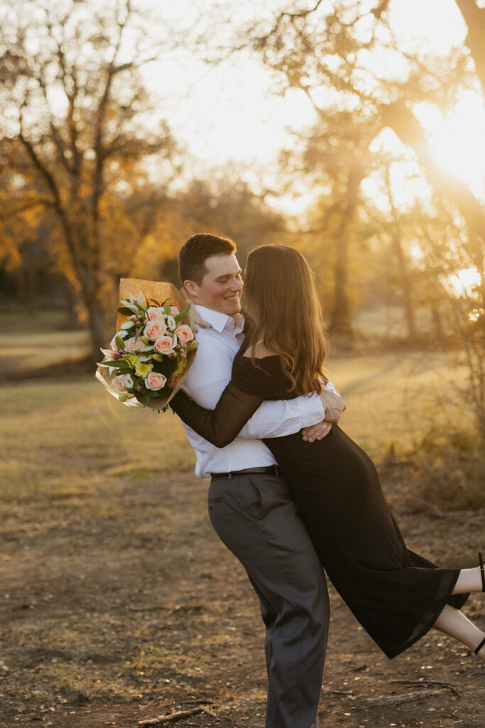 Man spinning his girlfriend for proposal photos at Waco Lake.