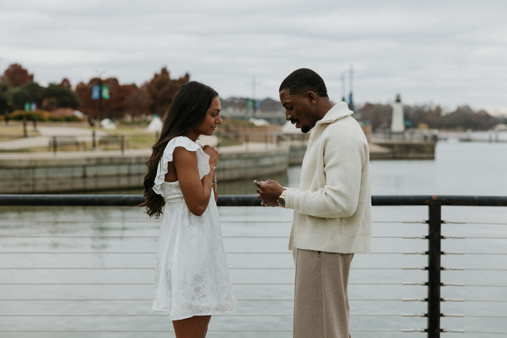 The man reading a heartfelt letter as the girlfriend smiles and listens.