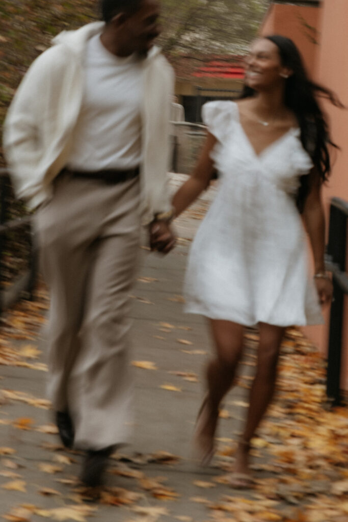 The couple playfully running together at The Harbor in Rockwall.