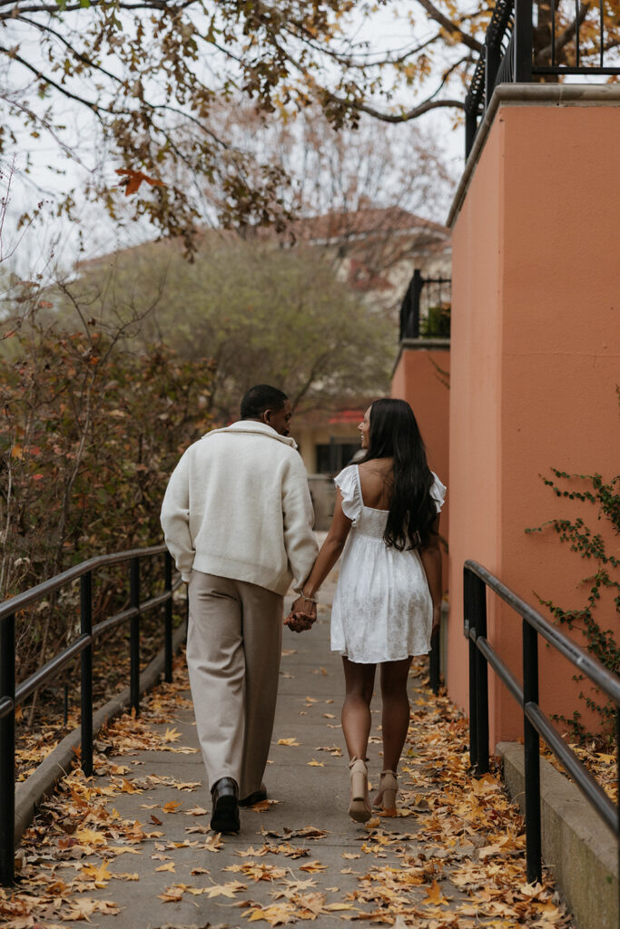 A couple holding hands and walking at The Harbor in Rockwall.