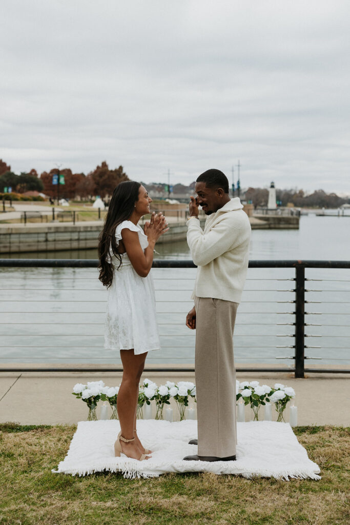 A couple standing together on a white blanket at The Harbor in Rockwall.