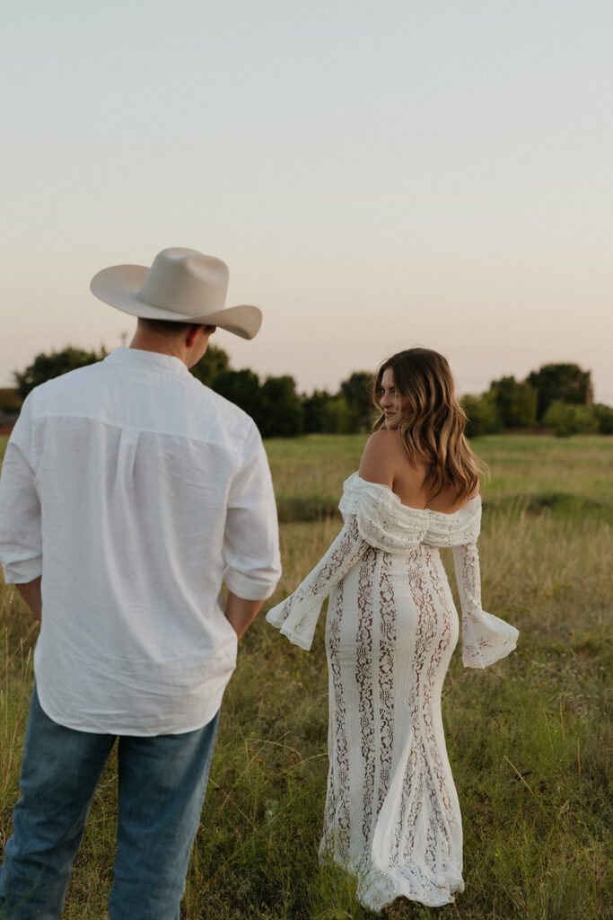 Woman playfully looking over her shoulder at her fiancée.