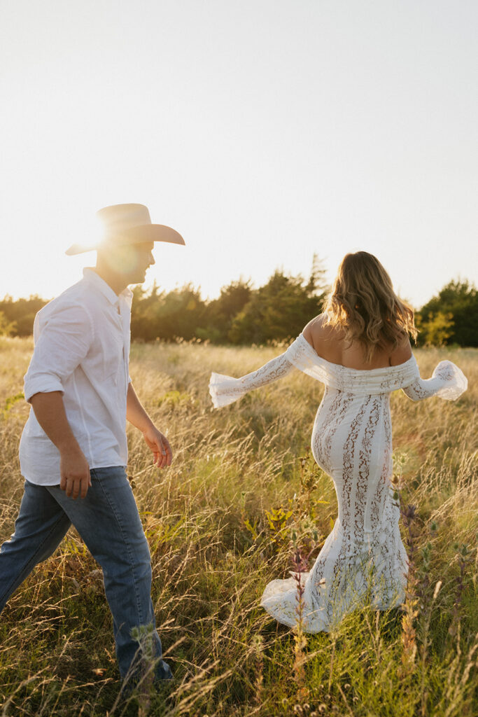 Couple playfully running in an open field during golden hour in Dallas, Texas.