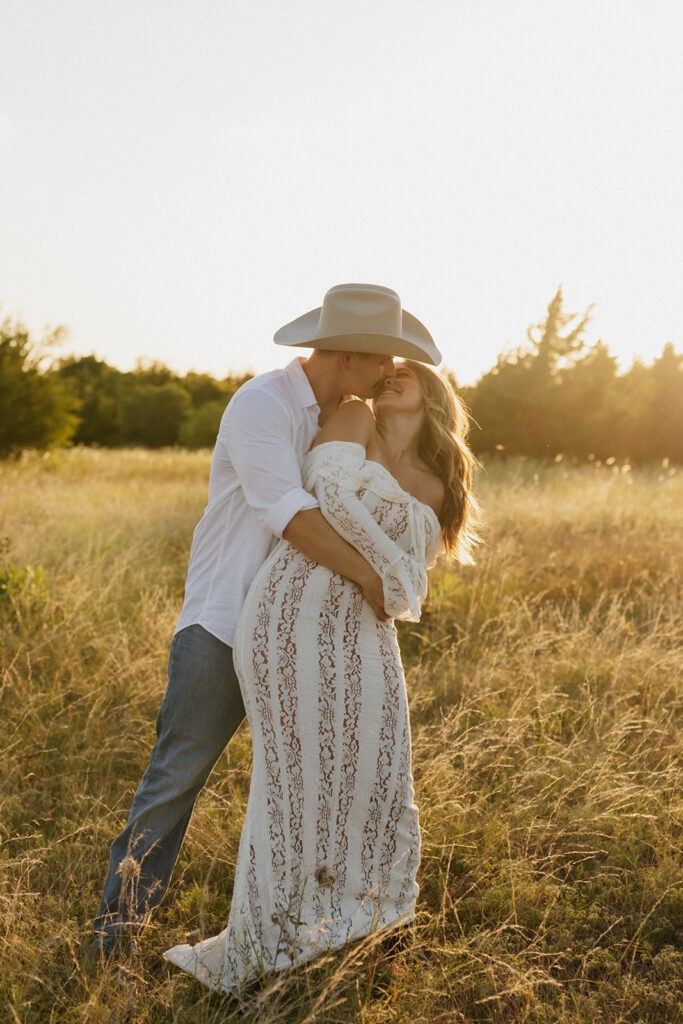 Man playfully hugging his fiancée from behind for summer engagement photos.