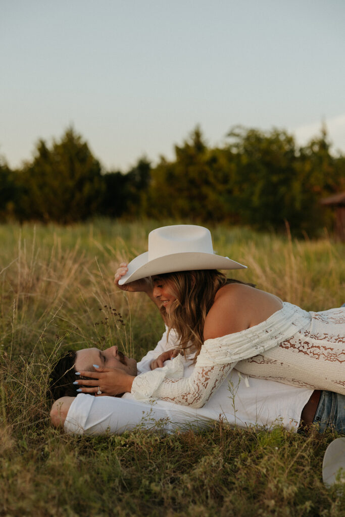 Summer engagement photos of a couple laying in a field in Dallas, Texas.