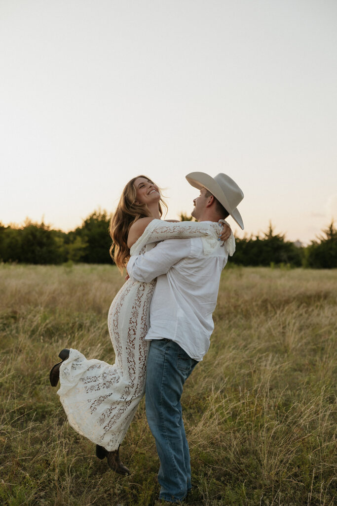 Woman smiling really big with her arms around her fiancé's neck.