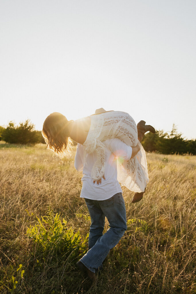 Man holding his fiancée in the air for candid, documentary photos.