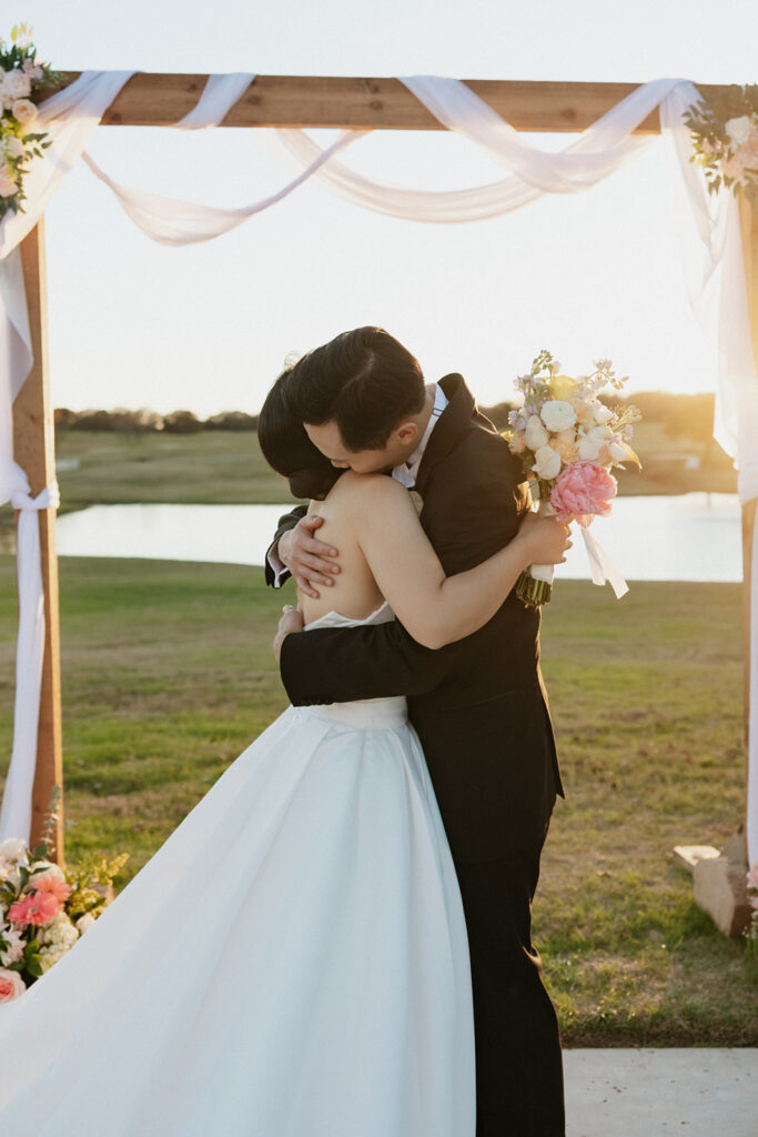 Bride and groom hugging at Bella Cavalli Events as the sun sets behind them. 