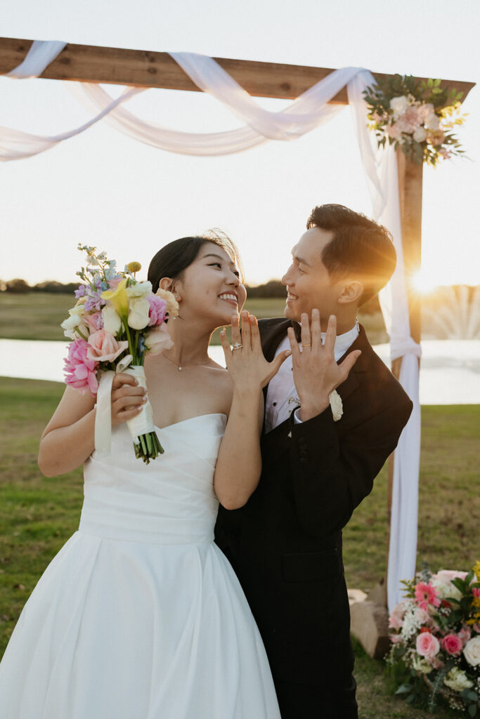 Bride and groom showing off their wedding rings during golden hour at Bella Cavalli Events.