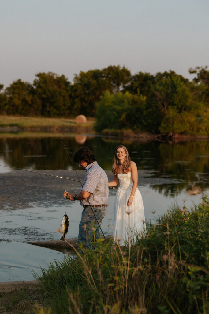 A woman smiling at her fiancé as he caught a fish.