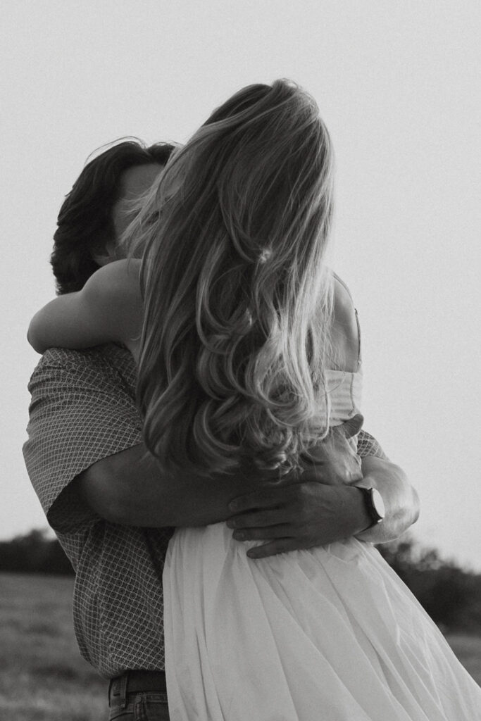 A couple spinning around with the woman's hair flowing in the wind.