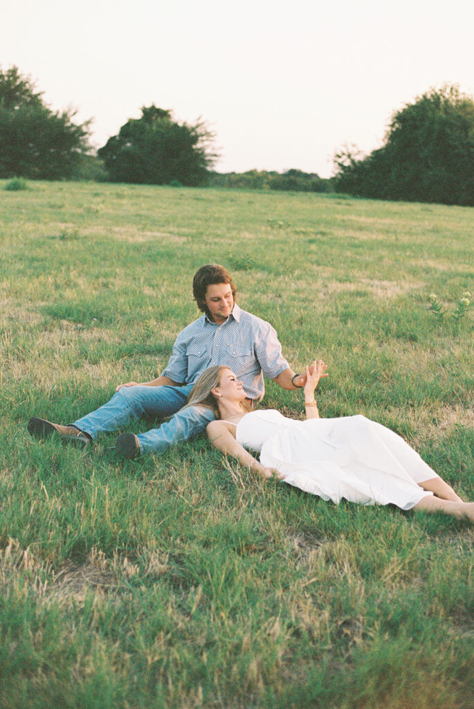 A couple romantically laying in the grass caught on 35mm film.