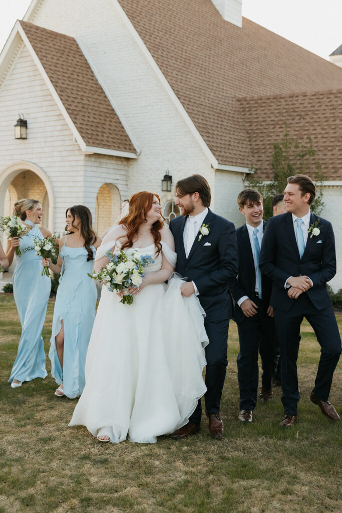 Wedding party walking and smiling outside of the venue at The Nest at Ruth Farms.
