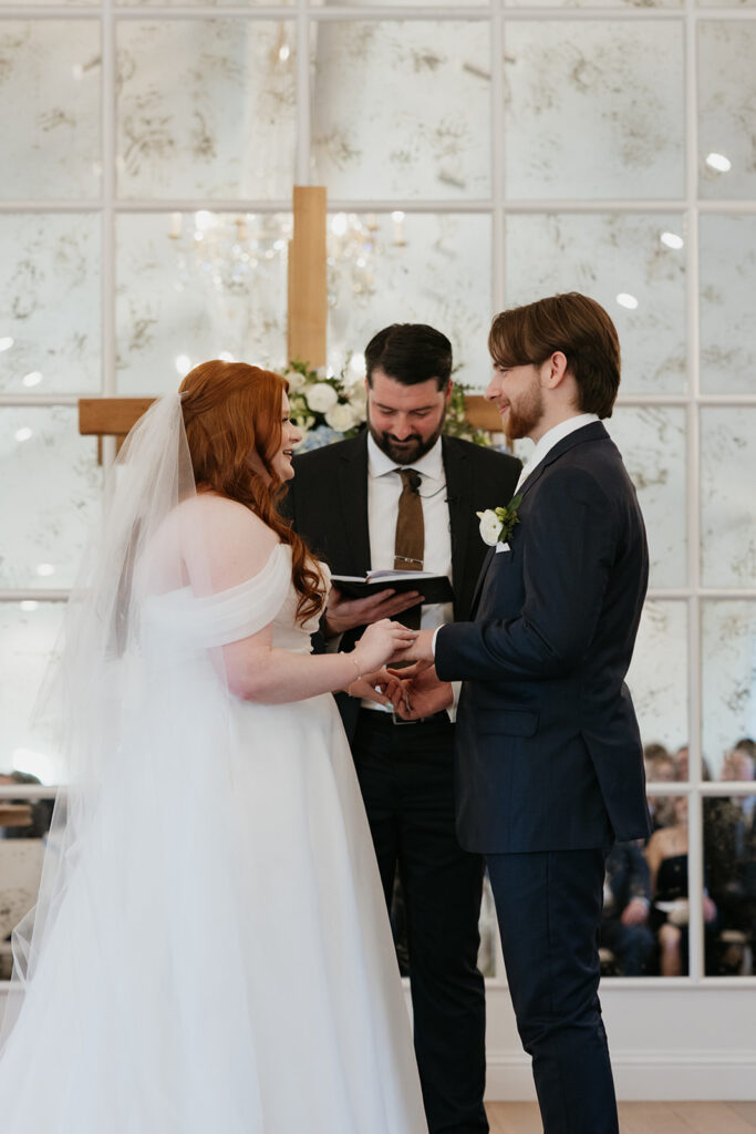 Bride and groom standing by a cross during their wedding ceremony at The Nest at Ruth Farms.