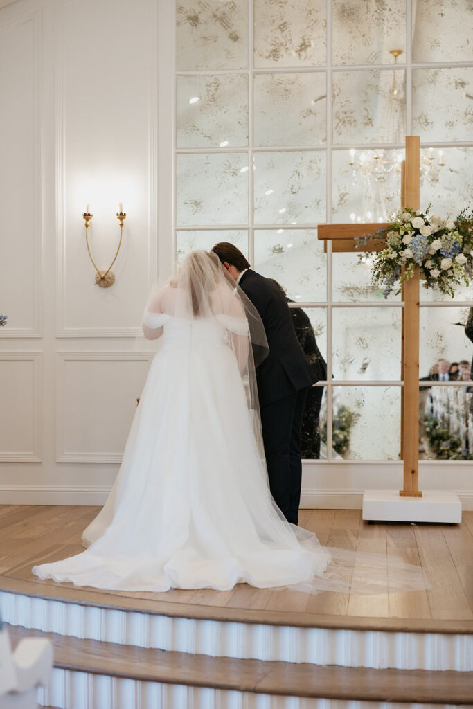 Bride and groom standing at a take taking communion during the wedding ceremony. 