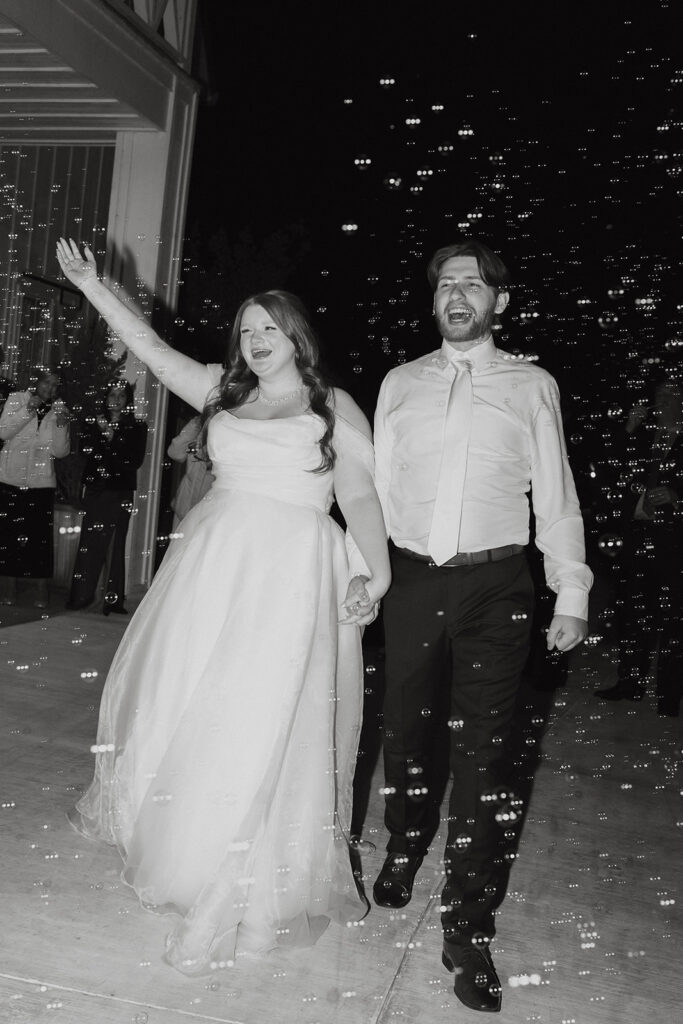 Bride and groom smiling as they exit the wedding at The Nest at Ruth Farms.