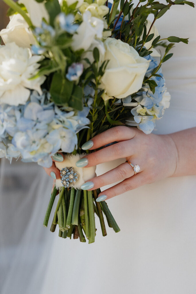 Bride holding her blue and white bouquet.