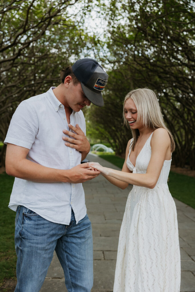 A couple smiling together while they look at the engagement ring.