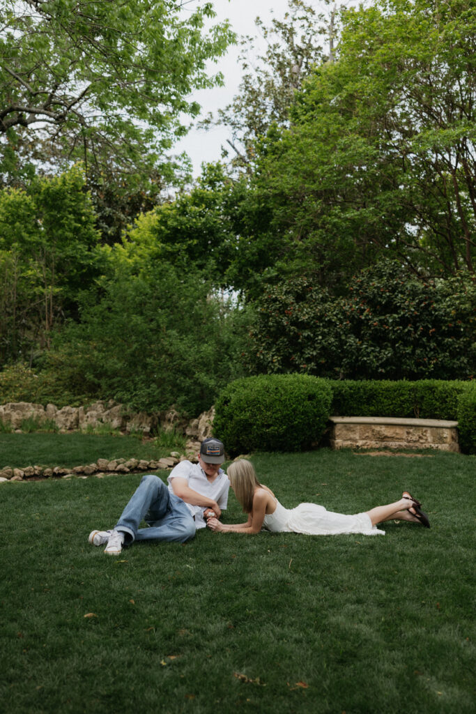 A couple sitting in the grass at the Dallas Arboretum.