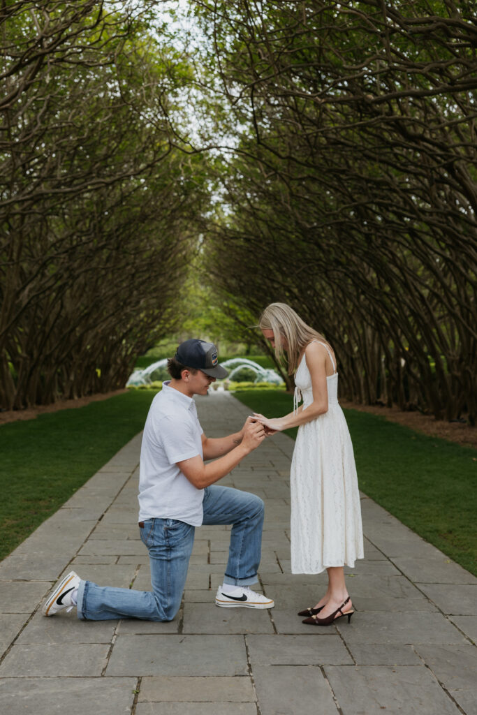 A Dallas Arboretum and Botanical Garden proposal where a man is putting a ring on the finger of his girlfriend.