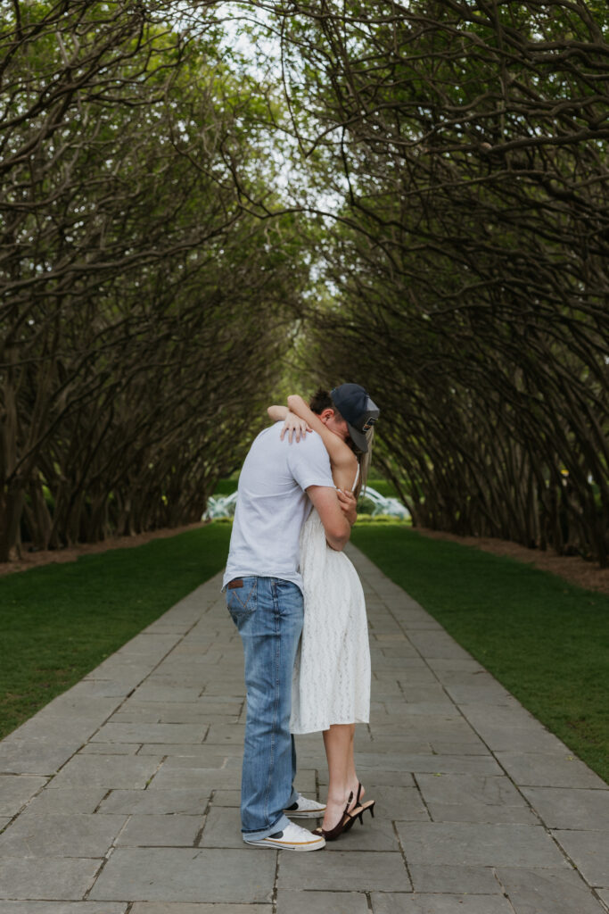 A couple hugging during the surprise proposal.