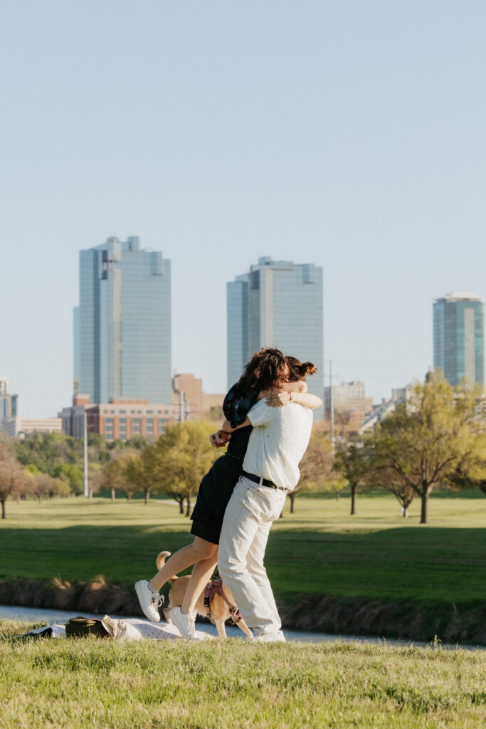 A couple hugging during their surprise proposal. 