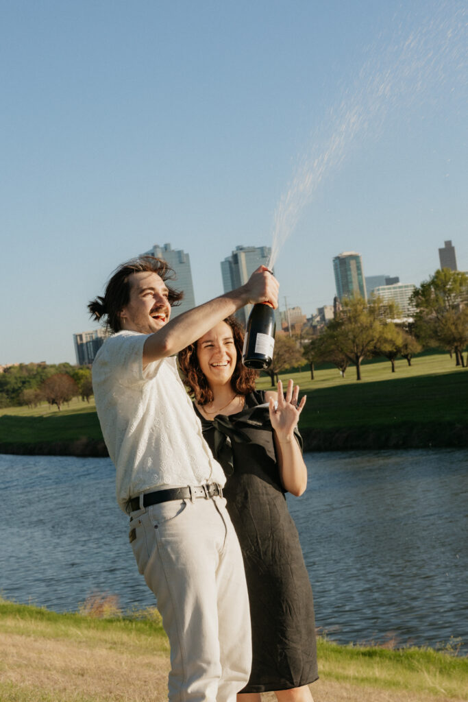 A couple spraying champagne at Trinity River in Fort Worth.