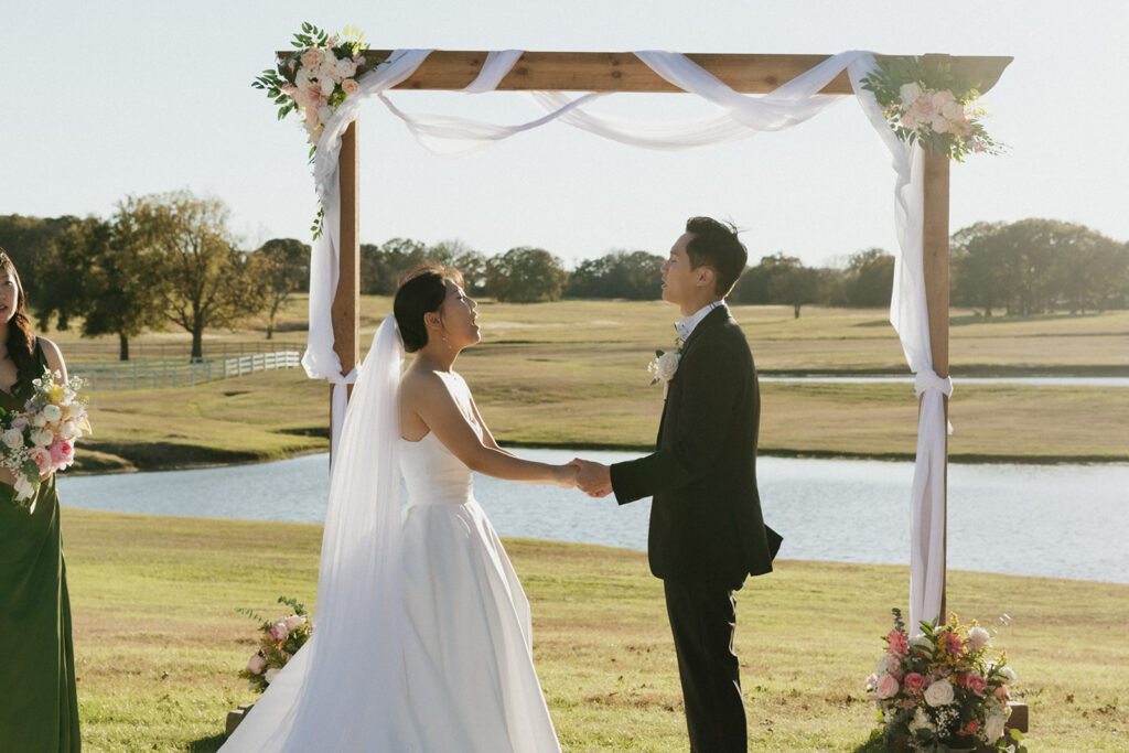 Bride and groom holding hands and worshiping during their wedding ceremony. 