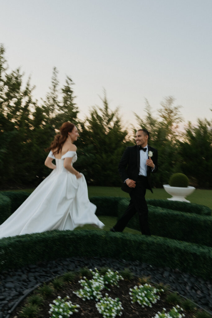 Bride and groom running playfully at The Hillside Estate. 
