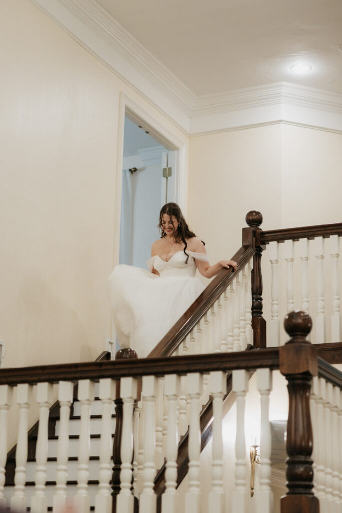 Bride running the staircase for the reception. 