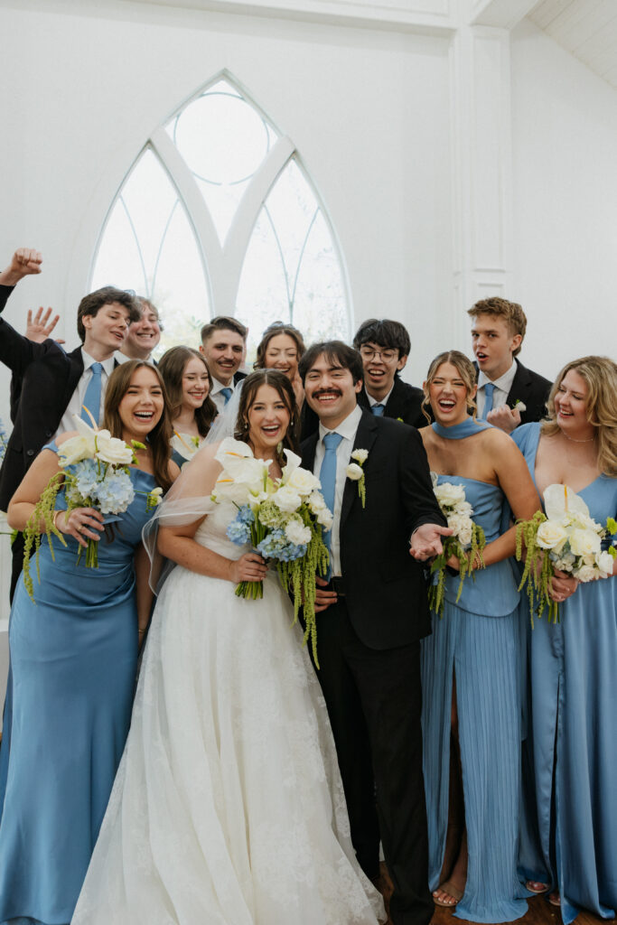 Wedding party smiling really big together. 