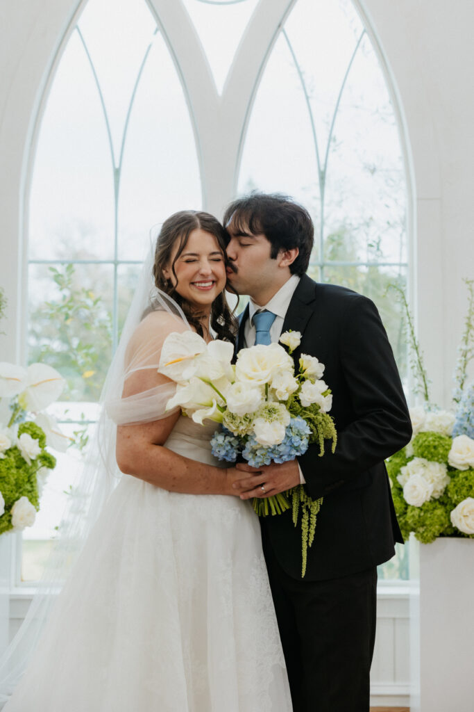 Groom kissing his bride on the cheek at The Springs Valley View Estate.
