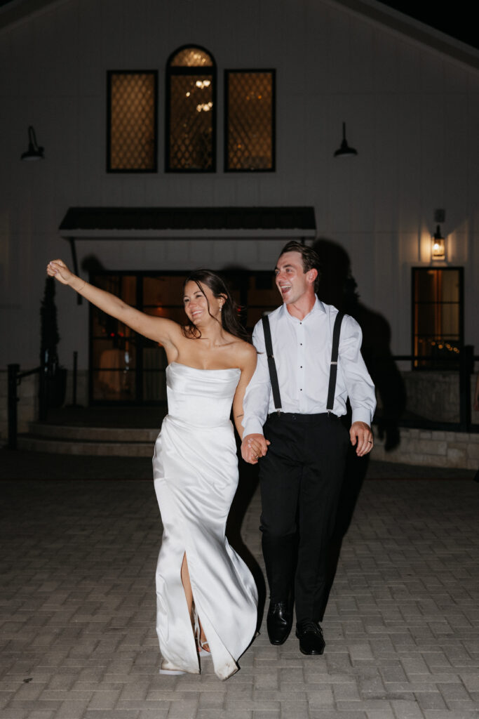Bride and groom smiling as they exit their wedding. 