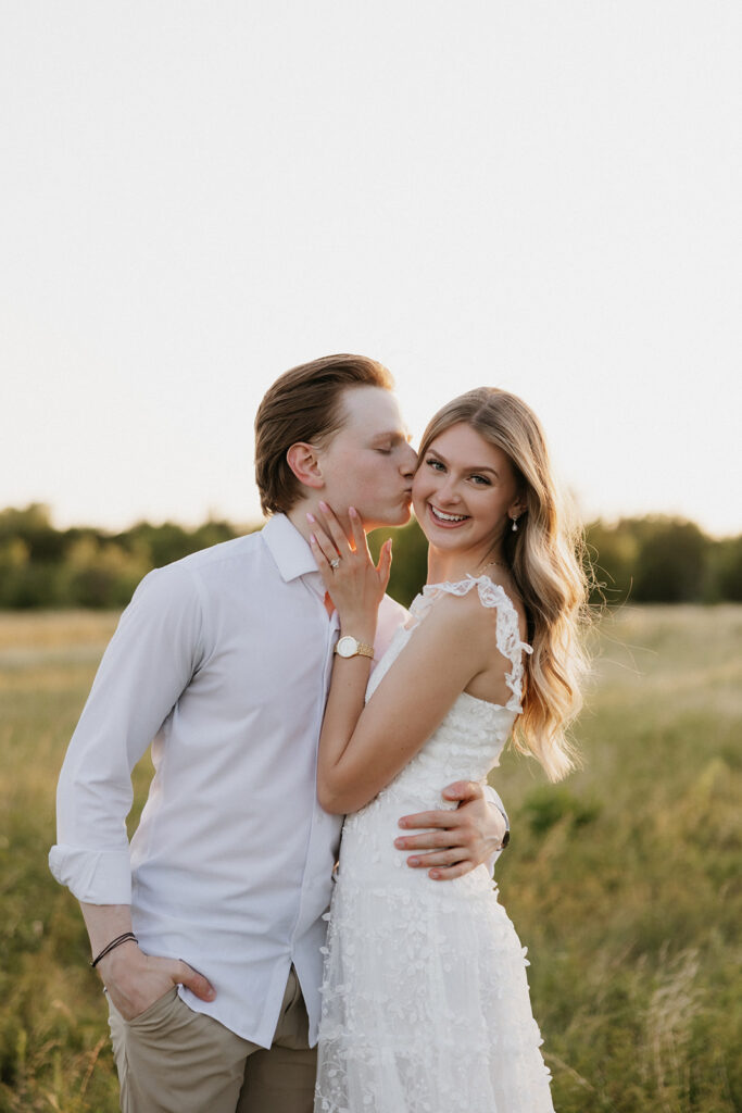 Man kissing his fiancée's cheek. 