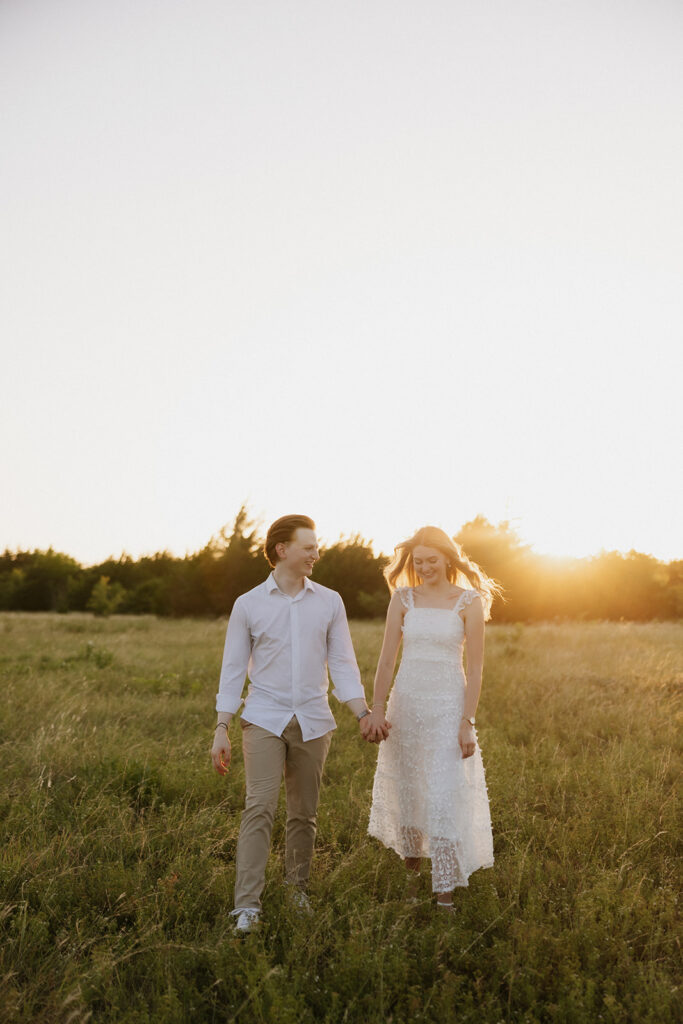 Couple walking and holding hands after their outdoor proposal. 