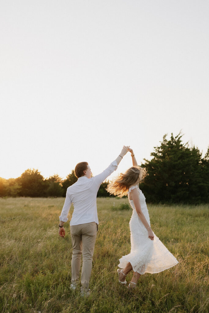 Couple dancing in a field during their outdoor proposal.
