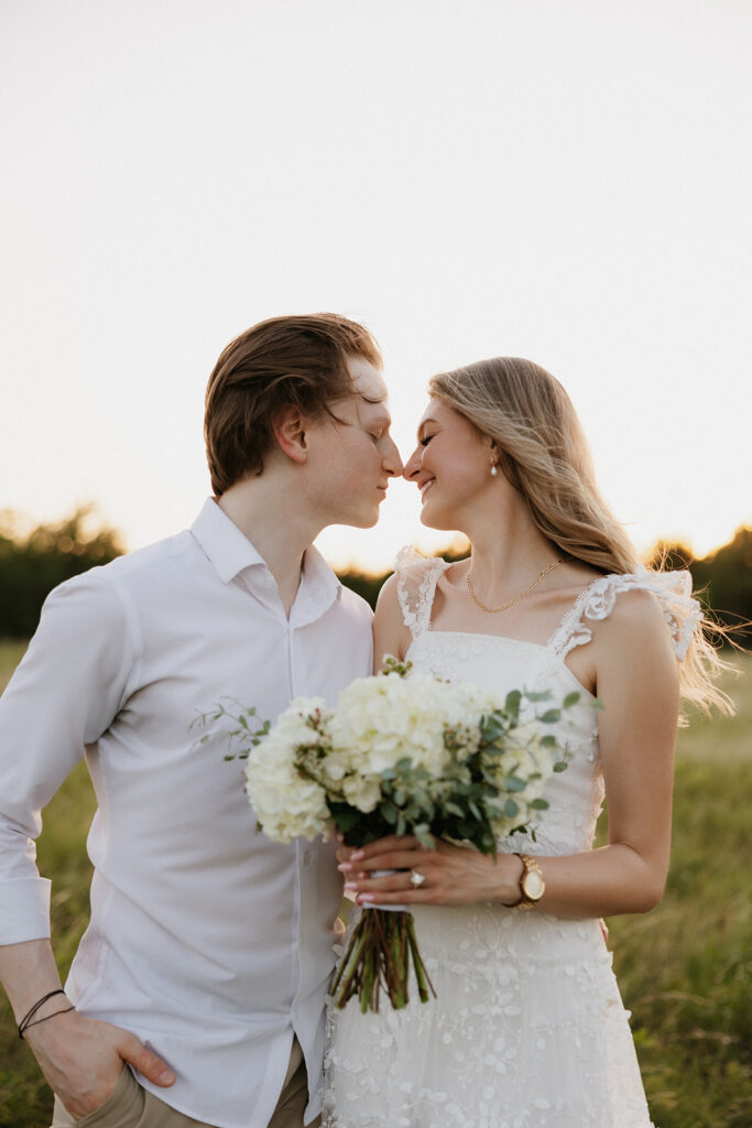 Couple about to kiss while holding a bouquet. 