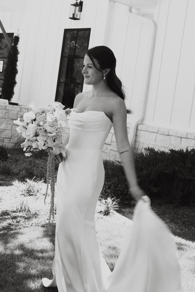 Bride holding her wedding dress train and bouquet.